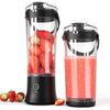 Two portable electric blender cups on a white background, one filled with fresh strawberries and the other containing a pink smoothie. The cups have black bases, clear plastic bodies, and clear lids with carrying handles.